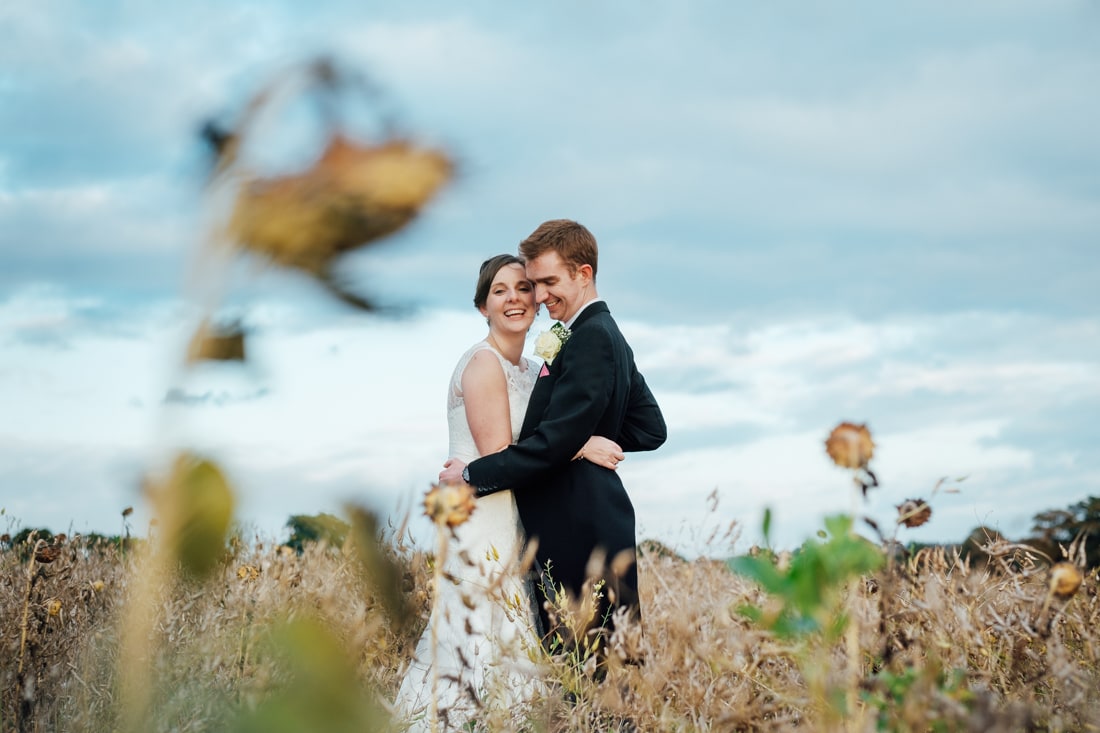 bride and groom in a sunflower field