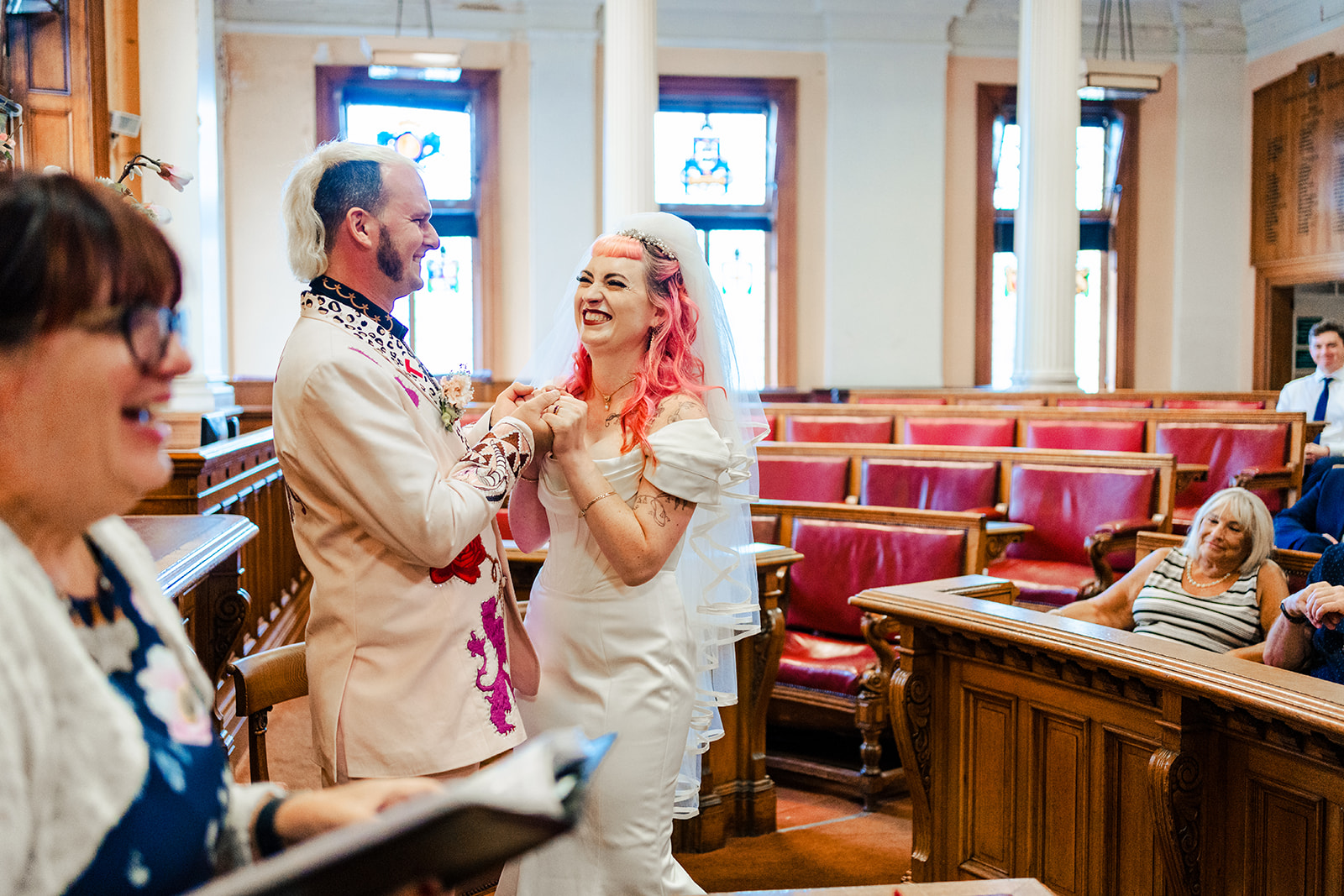 A bride and groom standing on the stairs of a building.