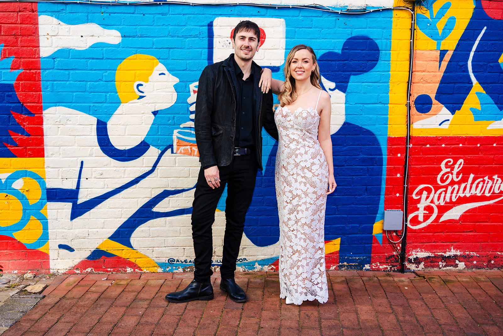 Joe and Amanda in front of a colourful mural