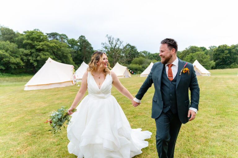 Bride and groom walking hand in hand at Knepp Estate