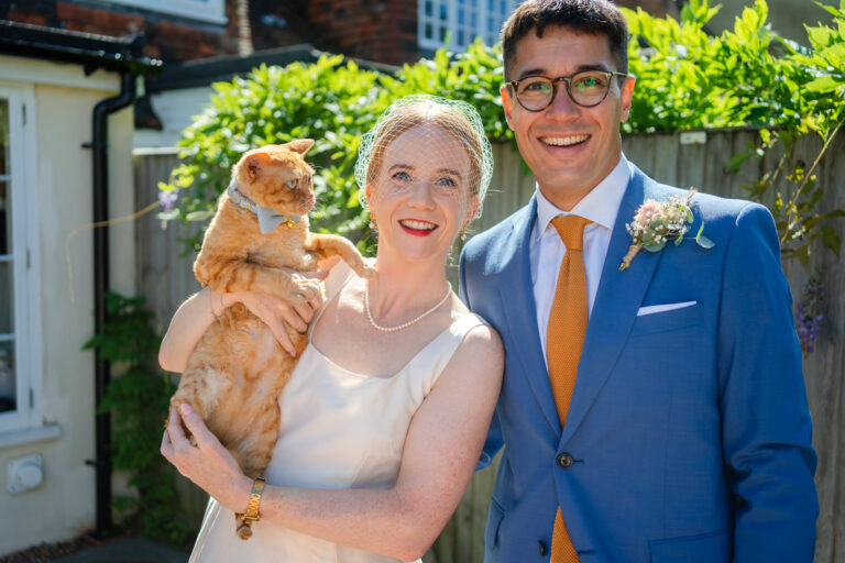 Bride holding her cat with the groom at their Canterbury wedding