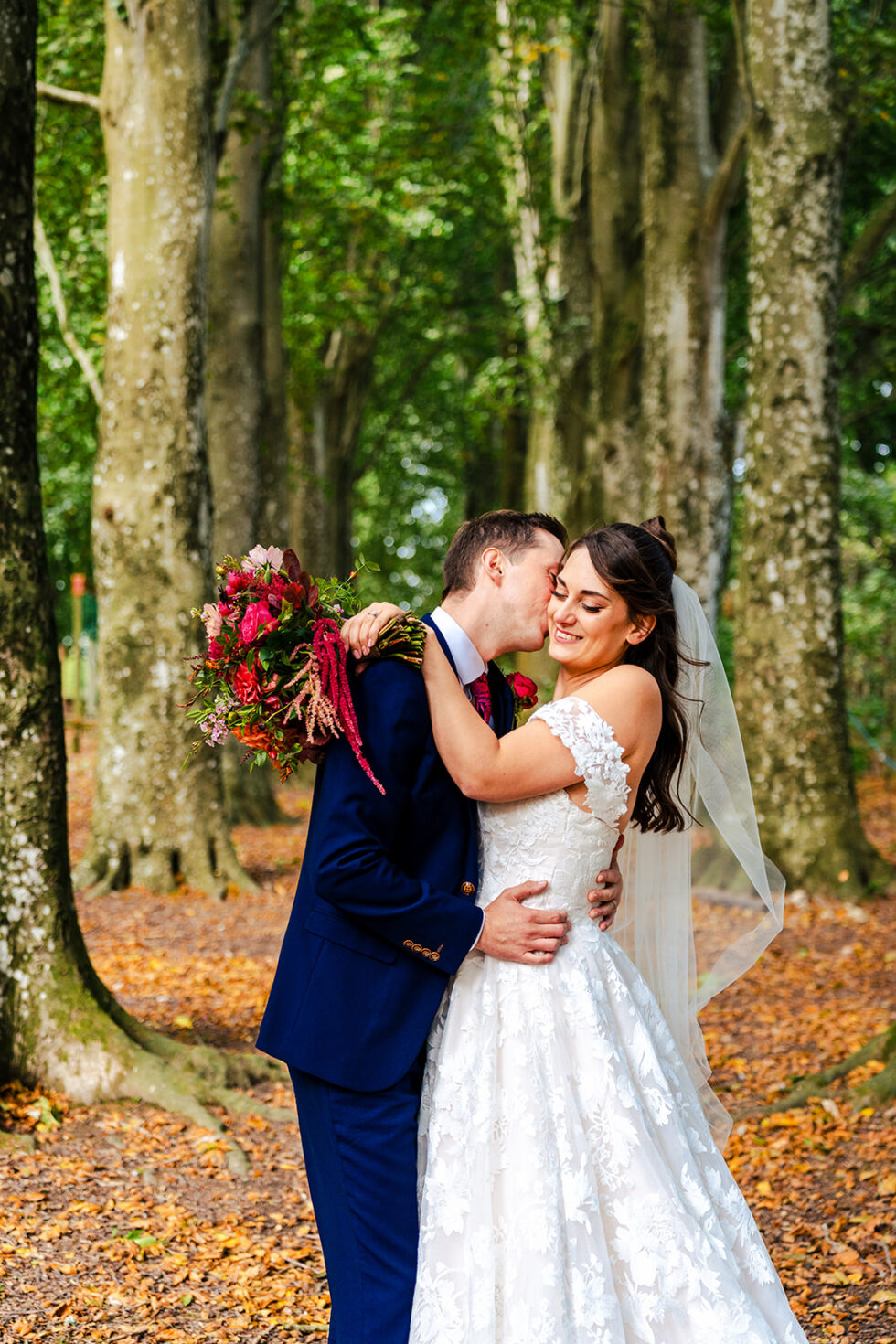 Steph and David kissing among the trees