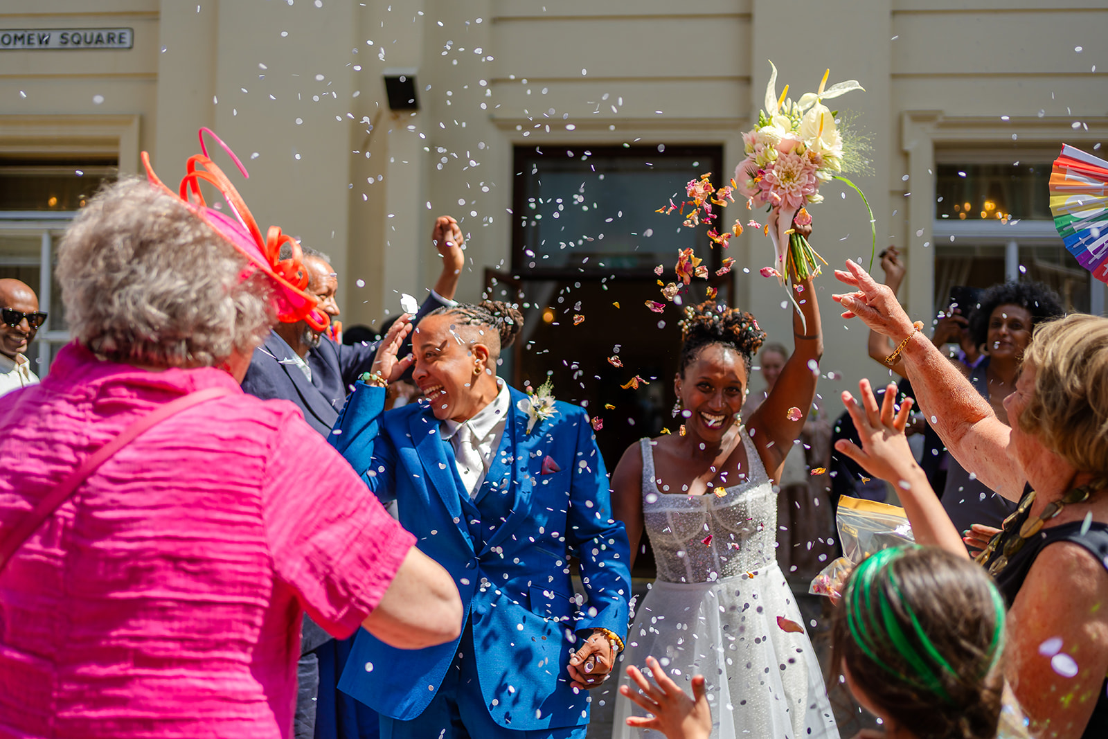 Azieb and Jules walking through confetti at Brighton Town Hall
