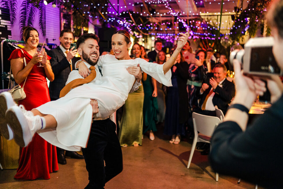 Guests lifting the bride at Sophie and Ed's Red Roaster wedding